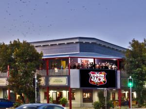 Un grupo de personas sentadas en el balcón de un edificio. en The Jack Backpackers, en Cairns