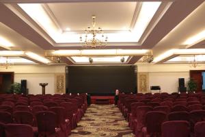 una sala de conferencias con una pizarra y sillas rojas en The Royal Marina Plaza Hotel Guangzhou en Cantón