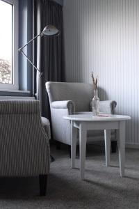 a living room with a table and a chair and a lamp at Tambohus Kro & Badehotel in Hvidbjerg