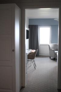 a room with a desk and a chair and a window at Tambohus Kro & Badehotel in Hvidbjerg