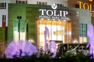 a tulp family park hotel with purple flowers in front of it at Tolip Family Park Hotel in Cairo