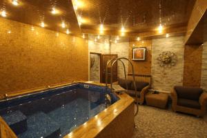 ein großes Schwimmbecken in einem Raum mit einem Zimmer in der Unterkunft Hotel Uyut Almaty in Almaty