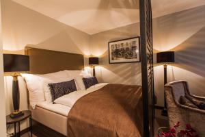 1 dormitorio con 1 cama, 2 lámparas y 1 silla en Saga Apartments Oslo en Oslo