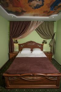 a bedroom with a large bed with a painting on the ceiling at Hotel John Gold in Anna