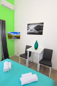 a room with a table and two chairs and a desk at Apartments Vodanović in Podgora +51 photos