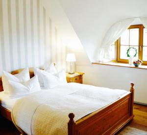 Schlafzimmer mit einem Bett mit weißer Bettwäsche und einem Fenster in der Unterkunft Landhaus Esperort in Ahrenshoop