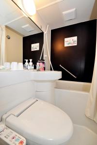Hotel Paco Obihiro Ekimae في أوبيهيرو: حمام به مرحاض أبيض وجدار أسود