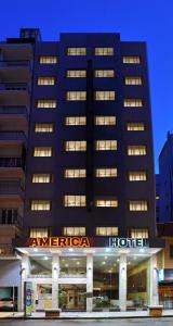 a large building with a hotel sign in front of it at Hotel América in Mar del Plata +7 photos