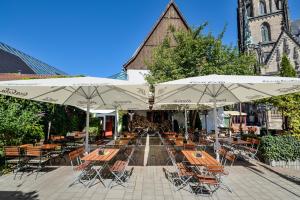 ein Café im Freien mit Tischen, Stühlen und Sonnenschirmen in der Unterkunft Gaststätte Brauhaus Zwickau GmbH in Zwickau