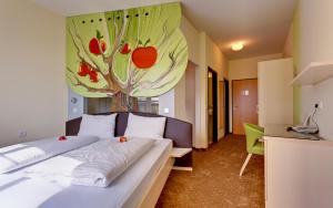 ein Schlafzimmer mit einem Bett und einem Gemälde an der Wand in der Unterkunft Pension Sonnengarten & Therme included - auch am An- & Abreisetag! in Lutzmannsburg