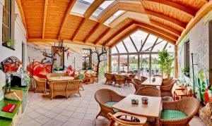 ein Restaurant mit Holzdecken und Tischen und Stühlen in der Unterkunft Pension Sonnengarten & Therme included - auch am An- & Abreisetag! in Lutzmannsburg