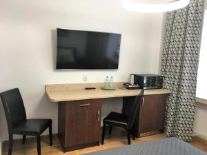 Pokój ten wyposażony jest w biurko z 2 krzesłami oraz telewizor z płaskim ekranem. w obiekcie Apartment 82A w Warszawie