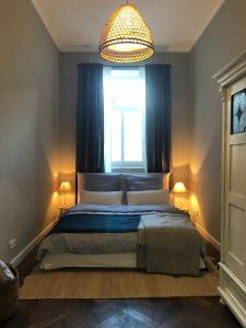 a bedroom with a bed with a window and a chandelier at Kaiser Ludwig´s wundervolle Ferienwohnung in Munich