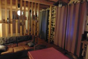 - un salon avec un canapé et quelques rideaux dans l'établissement La Loge, à Sanssac-lʼÉglise