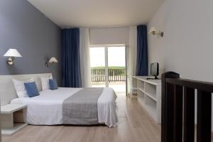 a hotel room with a bed and a balcony at Bella Vista Beach Club - All Inclusive in Sinemorets