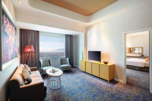 a hotel room with a couch and a bed at Hotel Ciputra Cibubur managed by Swiss-Belhotel International in Cibubur