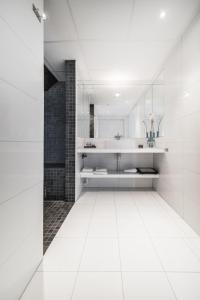 a white bathroom with a sink and a mirror at Malangen Resort in Mestervik