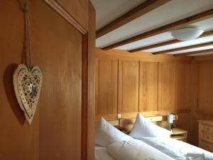 - une chambre avec un lit et un mur en bois dans l'établissement Alpenstern, à Gaschurn