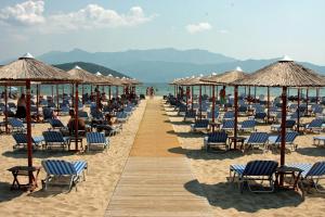 una playa con sillas y sombrillas y el océano en TETYK Keramoti Hotel Apartments en Keramotí