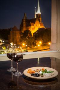 un plato de comida y dos copas de vino en una mesa en Great Polonia Wrocław Tumski en Breslavia