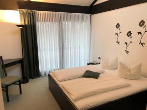 een slaapkamer met een bed en een raam met bloemen aan de muur bij Hotel My Schildow in Schildow