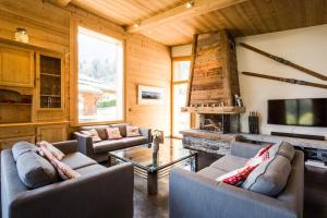 una sala de estar con sofás y TV en una cabaña en Chalet Base Camp, en Les Houches