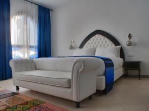 a bedroom with a white bed and a couch at Lina Ryad & Spa in Chefchaouene
