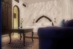 a hotel room with a bed and a table with a table sidx sidx at Lina Ryad & Spa in Chefchaouene