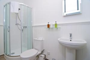 a white bathroom with a toilet and a sink at The Queens St Ives in St Ives