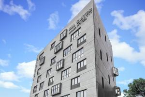 un edificio blanco alto con el cielo en el fondo en All Suites Bordeaux Centre Marne - Gare Saint-Jean, en Burdeos