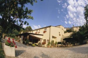 a large white building with flowers in front of it at Locanda Cacio Re in Vallo di Nera