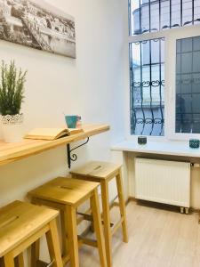 a room with wooden tables and benches and a window at Laisves Avenue Hostel "Easy Kaunas" in Kaunas