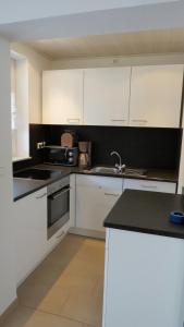a kitchen with white cabinets and a black counter top at "Schoene Aussicht" in Burgen
