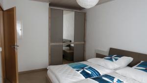 1 Schlafzimmer mit 2 Betten mit blauen und weißen Kissen in der Unterkunft "Schoene Aussicht" in Burgen