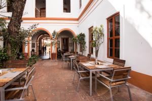 a restaurant with wooden tables and chairs in a courtyard at Dune de L'orient in Puducherry