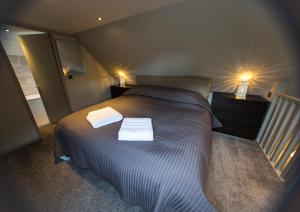 a bedroom with a bed with two towels on it at Cairn Leuchan in Ballater