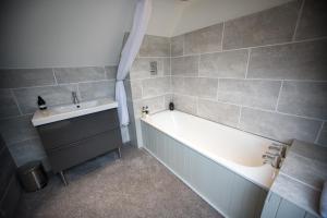 a bathroom with a bath tub and a sink at Cairn Leuchan in Ballater