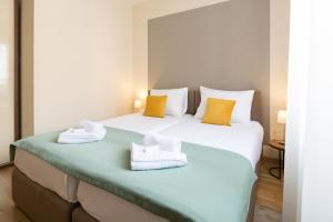 duas camas num quarto de hotel com toalhas em Prime Hotel Garni em Belgrado