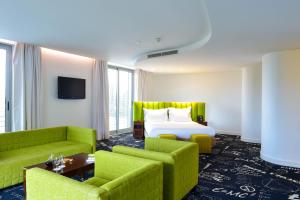 a hotel room with a bed and two green chairs at Hotel da Estrela - by Unlock Hotels in Lisbon