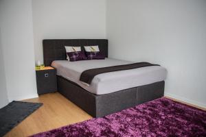 a bedroom with a large bed with a purple rug at Apartments in Bern - Breitenrainplatz in Bern