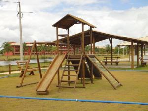 a wooden playground with a slide and a roof at Condomínio Villa das Aguas com wi-fi in Praia do Saco