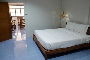 a bedroom with a large bed with white sheets at 7 Rooms Kohchang in Ko Chang
