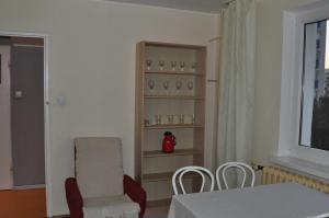 a living room with a table and chairs and a shelf with glasses at Apartament z Widokiem in Gdynia