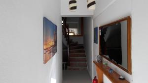 un corridoio con una scala e un televisore a parete di Prosforio Rooms a Ouranoupoli