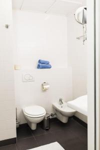 a white bathroom with a toilet and a sink at Ofenloch Apartments in Vienna