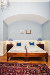 ウィーンにあるOfenloch Apartmentsのベッドルーム1室(ベッド1台、ランプ2つ、ラグ付)