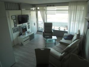 a living room with a couch and a chair and a television at Lütte Höög in Sierksdorf