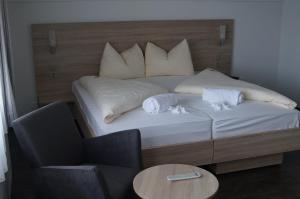 a bed with two pillows and a table and a chair at Hotel Kreuz in Leissigen