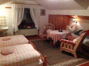 ein Wohnzimmer mit einem Tisch und Stühlen sowie ein Zimmer in der Unterkunft Gästehaus Färbinger in Bayerisch Gmain