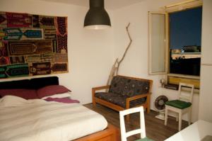 sypialnia z łóżkiem, krzesłem i oknem w obiekcie BEACHBAR Apartment in Rome w Rzymie